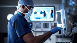 Shot of a surgeon looking at a monitor in an operating room